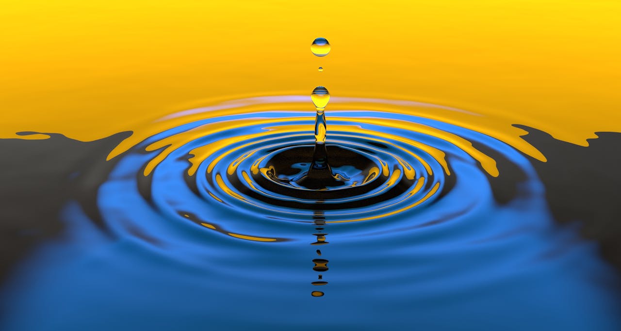 Close-up macro shot of a water droplet creating ripples with vibrant colors.